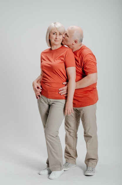 coppia innamorata in magliette arancioni su sfondo bianco