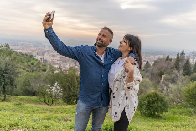 Coppia innamorata si fa un selfie al tramonto con lo smartphone