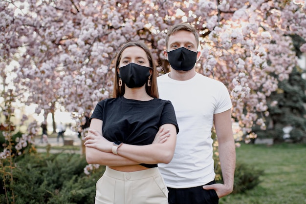 Coppia innamorata uomo e donna che si baciano in maschera medica protettiva sul viso