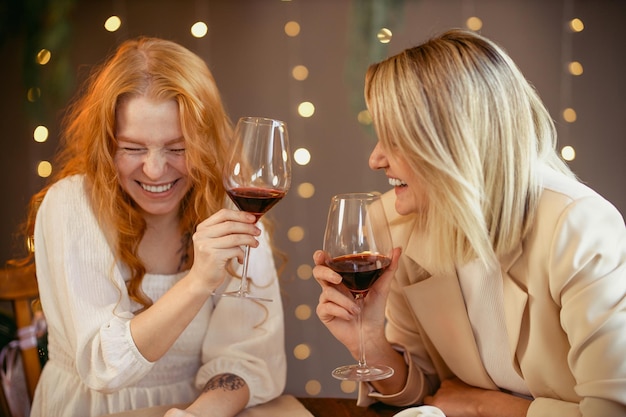 Coppia lesbica a cena in un ristorante. Le ragazze bevono vino e parlano