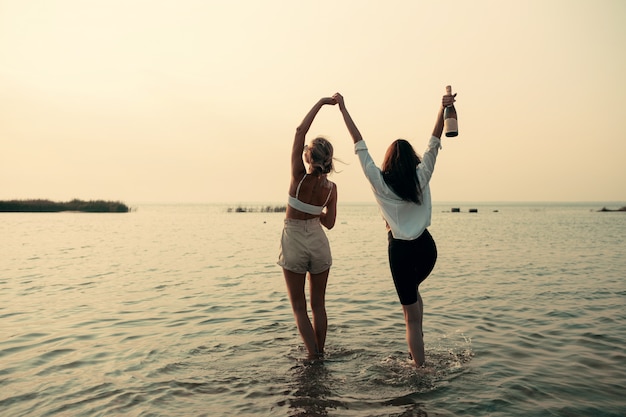 Coppia lesbica divertirsi sulla spiaggia Belle donne amiche felici rilassarsi vicino al mare