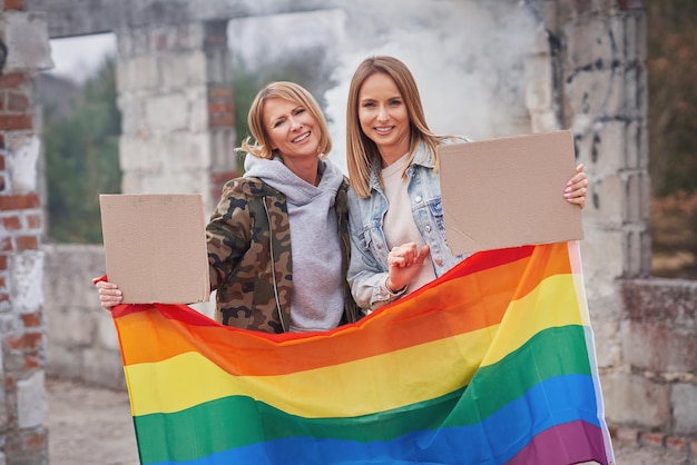 Coppia lgbt con bacheca vuota e bandiera