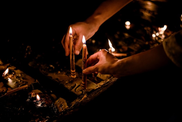 Coppia mani illuminazione a lume di candela nel tempio tailandese di notte, Chiang mai, Thailandia