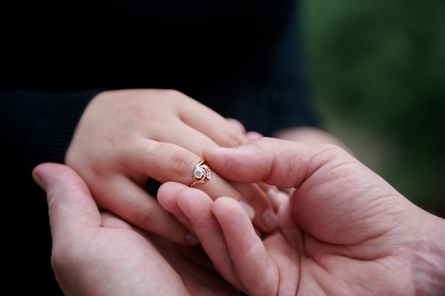 Coppia mano nella mano con anello di diamanti