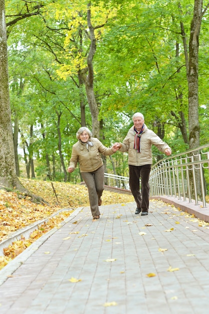 Coppia matura che si diverte nel parco autunnale