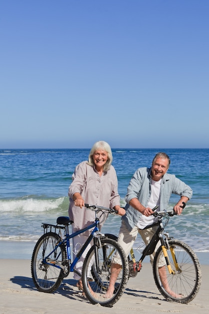 Coppia matura con le loro biciclette sulla spiaggia