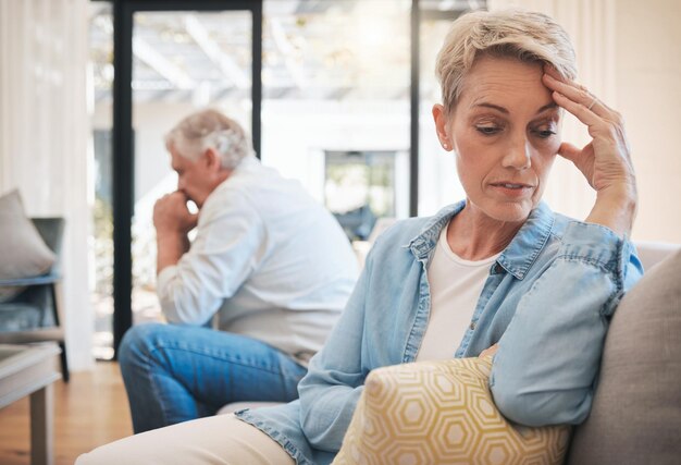 Coppia matura lotta contro lo stress o il divorzio nel soggiorno della casa o nel divano interno della casa Donna arrabbiata, triste o depressa, faccia di donna con ansia nella discussione sulla relazione traditrice con l'uomo nella consulenza sulla terapia matrimoniale