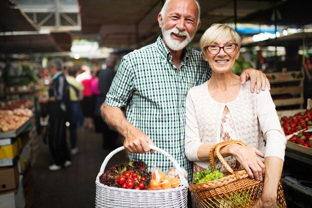 Coppia matura shopping frutta e verdura sul mercato. Dieta sana.