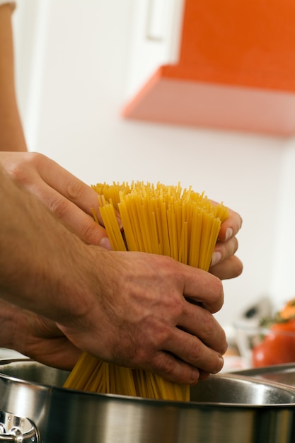 coppia mettendo la pasta in una pentola