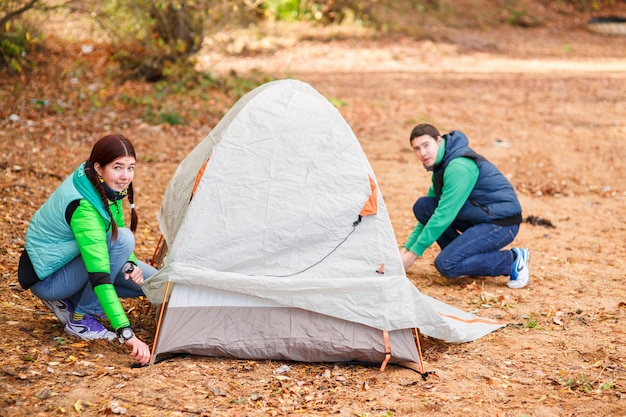 Coppia monta tenda in campagna