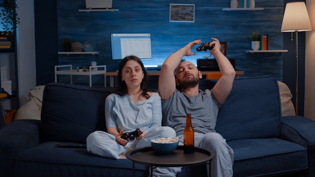 Coppia nervosa sconvolta che perde la competizione di videogiochi online usando il joystick