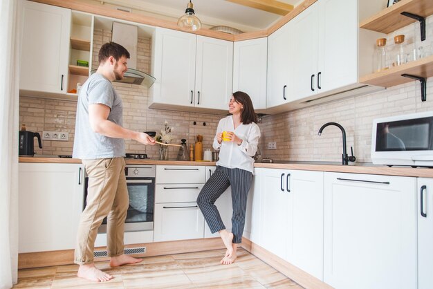 Coppia parlando in cucina uomo che cucina la colazione