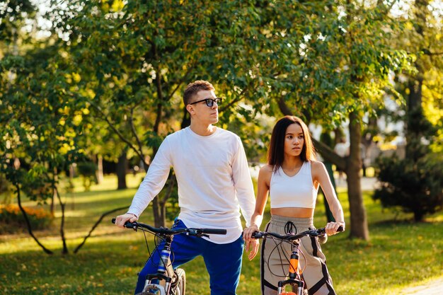 Coppia premurosa concentrata di ciclisti che guardano la luce del sole nel parco cittadino