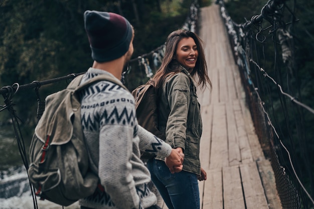 Coppia romantica. Bella giovane coppia che si tiene per mano mentre cammina sul ponte sospeso