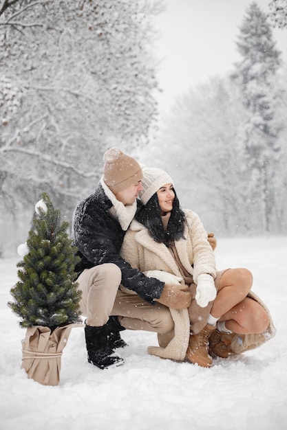 Coppia romantica che cammina nella foresta al giorno d'inverno