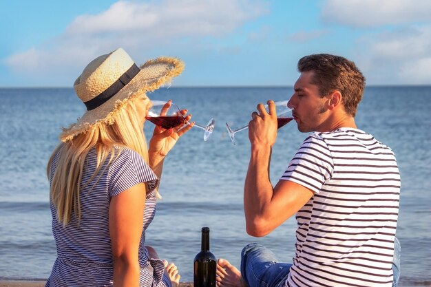 Coppia romantica gustando il vino in riva al mare