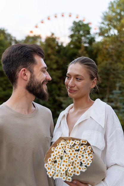 Coppia romantica insieme alla ruota panoramica nel parco