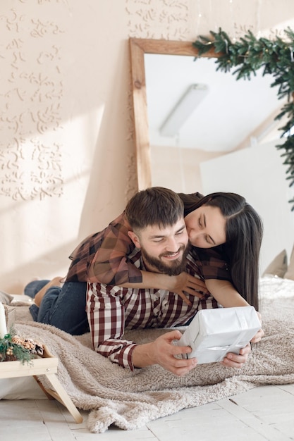 Coppia romantica posa su una coperta con una scatola regalo