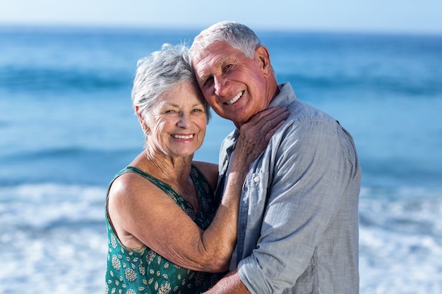 Coppia senior abbracciando in spiaggia