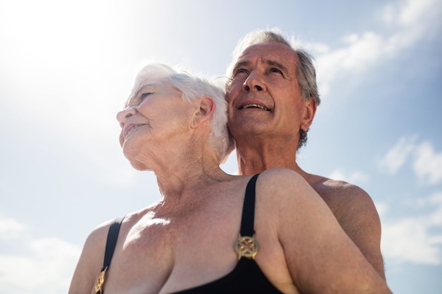 Coppia senior abbracciando in spiaggia