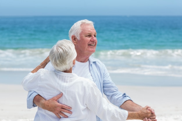 Coppia senior ballare in spiaggia