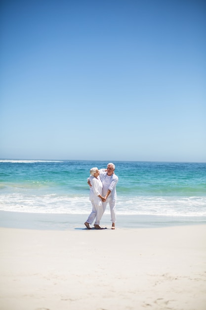 Coppia senior ballare in spiaggia