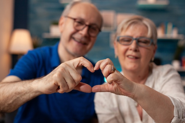 Coppia senior che crea una figura a forma di cuore con le mani