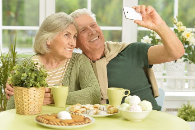 Coppia senior che si fa selfie con il telefono a casa