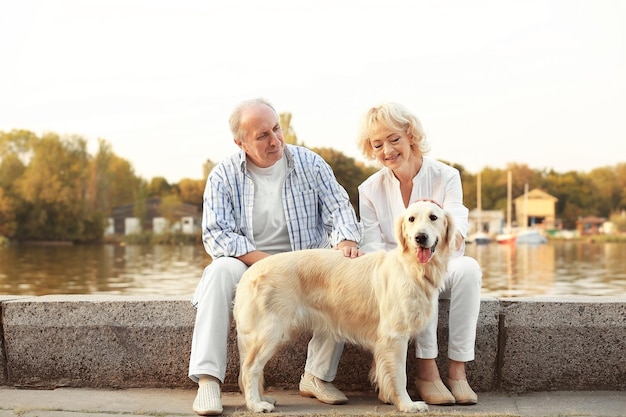 Coppia senior e grosso cane sul bund