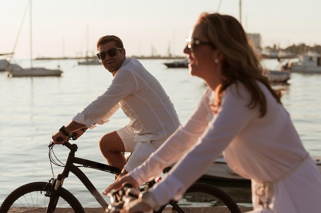 Coppia senior godendo di una bella mattinata insieme in sella a una bicicletta in riva al mare messa a fuoco selettiva