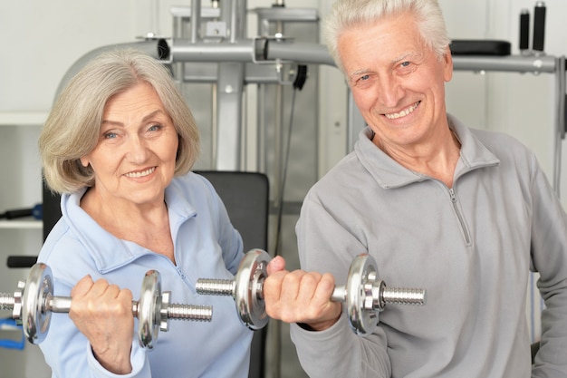 Coppia senior sorridente attiva che si esercita in palestra