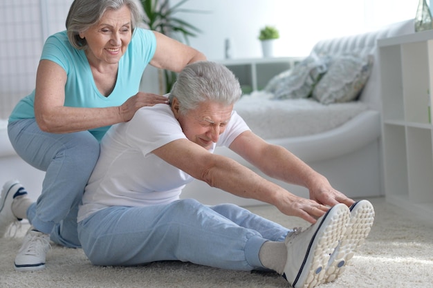 Coppia senior sorridente attiva che si esercita in palestra