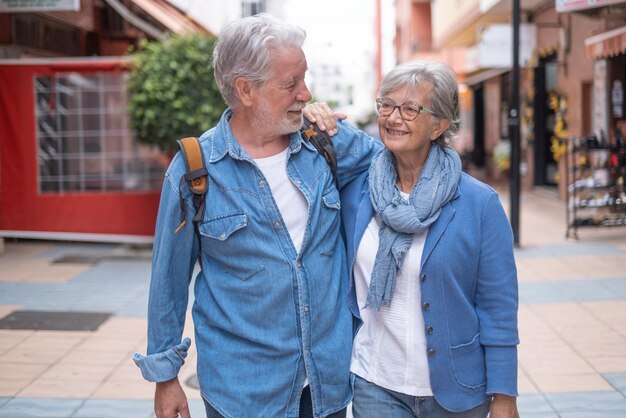 Coppia senior sorridente felice di turisti che camminano in città godendo della libertà di vacanza di viaggio