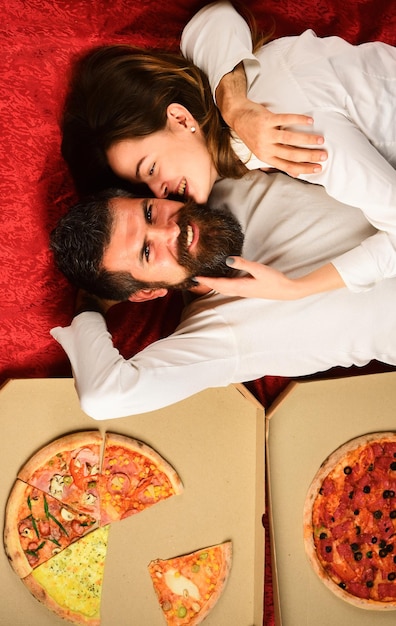 Coppia sexy mangiare pizza a letto a casa coppia appassionata giovani amanti felice allegro uomo e donna