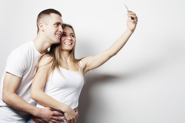 Coppia sorridente con smartphone, selfie e divertimento.