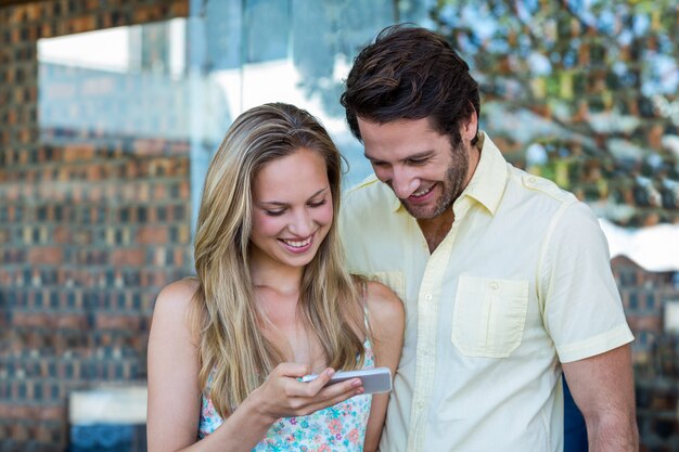 Coppia sorridente guardando smartphone