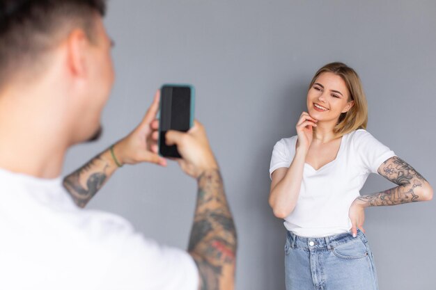 Coppia sorridente utilizzando i telefoni in studio Sfondo scuro isolato