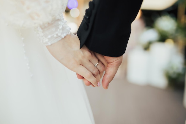 coppia sposata che si tiene per mano nel giorno del matrimonio