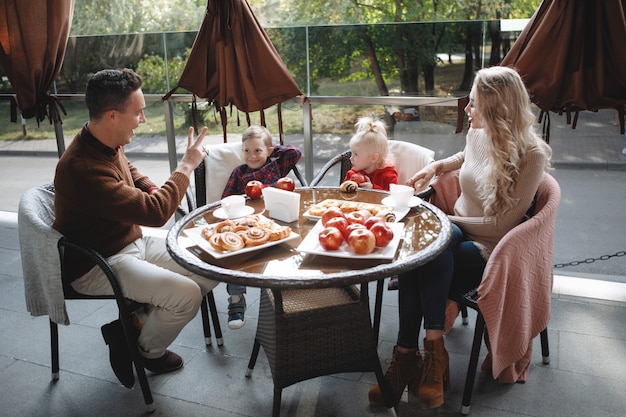 Coppia sposata con figli, figlia e figlio a un tavolo in un caffè. Felice coppia tradizionale, felicità familiare.