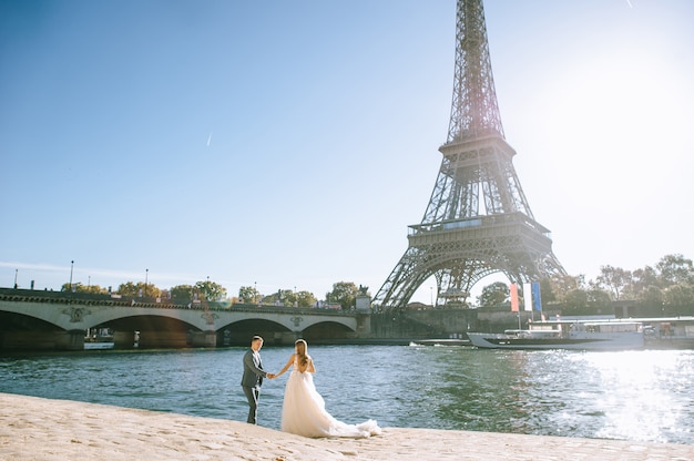 Coppia sposata romantica felice che abbraccia vicino alla torre Eiffel a Parigi