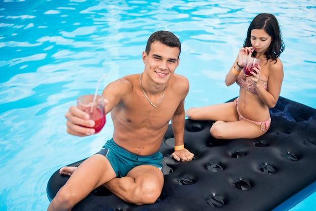 Coppia sul materasso gonfiabile in piscina