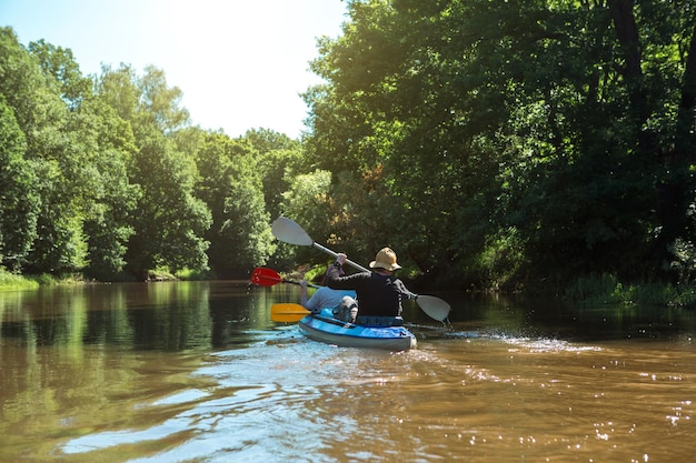 Coppia uomo e donna in famiglia viaggio in kayak barca a remi sul fiume un'escursione in acqua un'avventura estiva Ecofriendly ed estremo turismo stile di vita attivo e sano