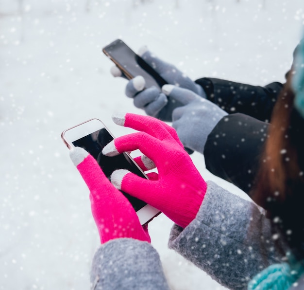 Coppia usando lo smartphone in inverno con guanti per touch screen