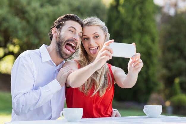 Coppia usando prendendo un selfie sul cellulare