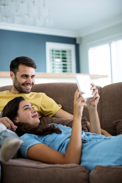 Coppia utilizzando la tavoletta digitale nel soggiorno di casa