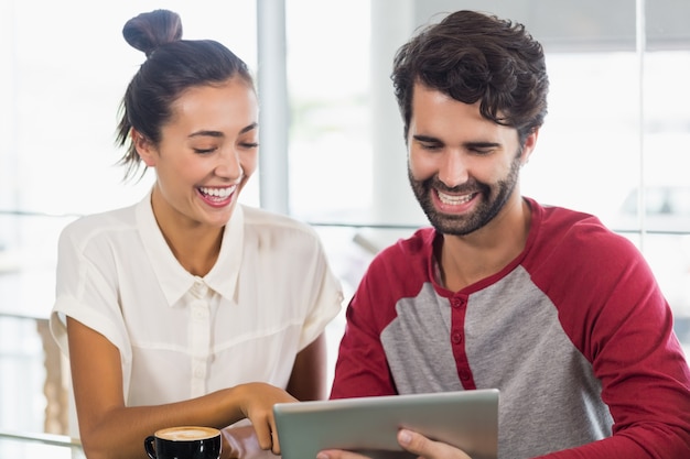 Coppia utilizzando la tavoletta digitale nella caffetteria