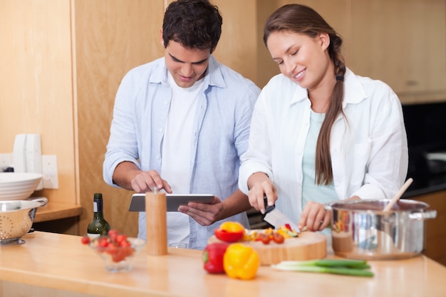 Coppia utilizzando un tablet PC per cucinare