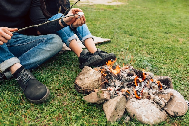 Coppia vicino al falò tostatura marshmallow