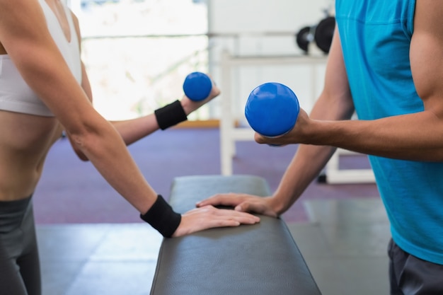 Coppie adatte che si esercitano con i dumbbells blu