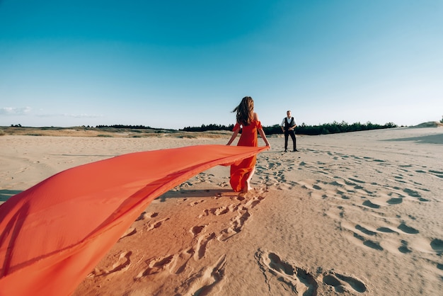 Coppie adorabili eleganti che posano sulla spiaggia